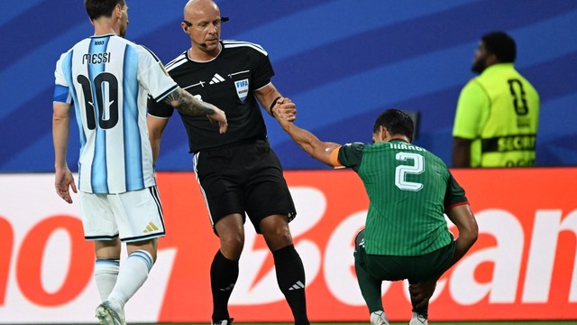 Mandi é levantado pelo árbitro após sofrer uma falta dura de Messi