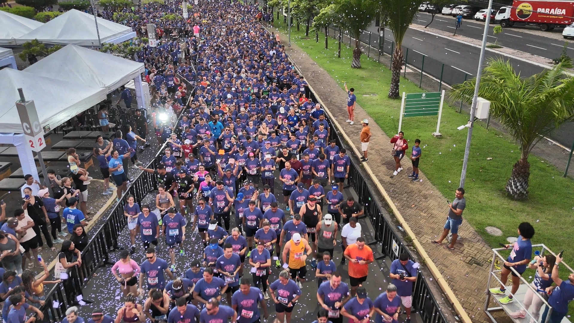 Atletas correndo durante uma prova de rua com o percurso ao fundo