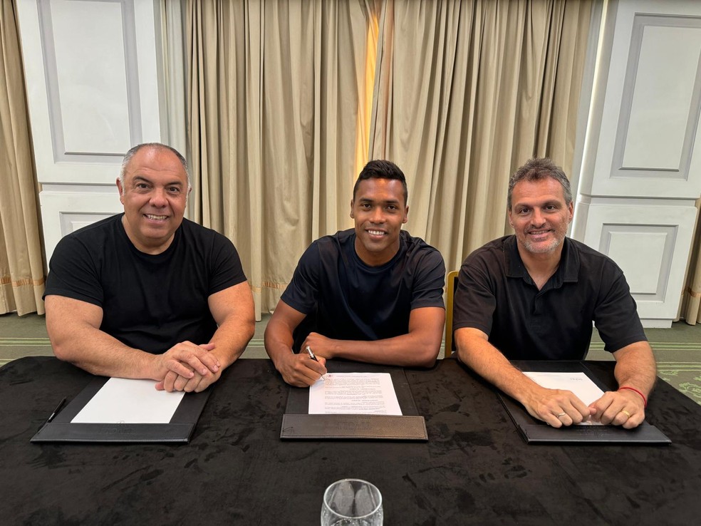 Alex Sandro assina contrato com o Flamengo ao lado de Marcos Braz e Bruno Spindel � Foto: Divulga��o