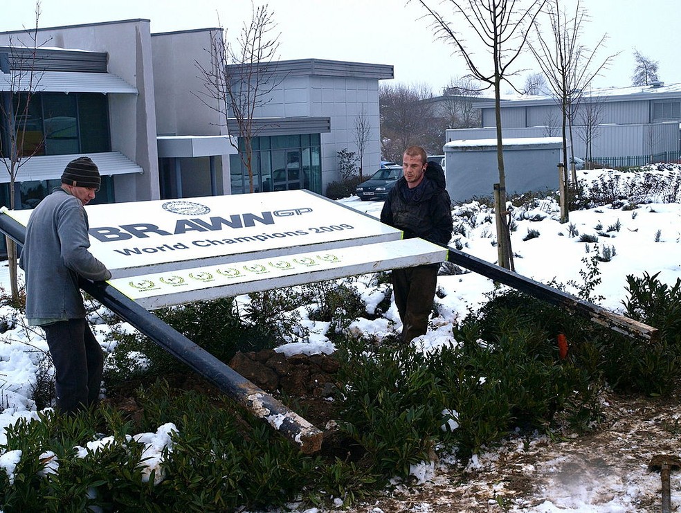 Remoção de placa com nome da Brawn GP na fábrica de Brackley, em 2010, para instalação da Mercedes — Foto:  MAX NASH/AFP via Getty Images
