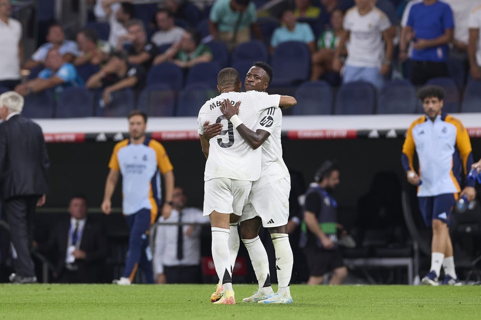 Vinicius Junior abraça Mbappé após gol marcado em Real Madrid x Betis — Foto: Getty Images