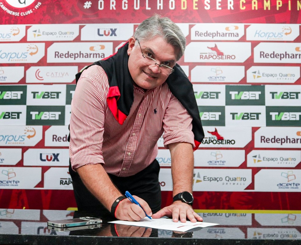 Lênin Correia assinando a ata de posse, no Renatão — Foto: Samy Oliveira / Campinense