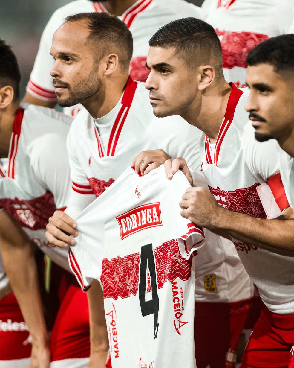 Jogadores do CRB seguram a camisa de Luís Segovia — Foto: Dido Henrique