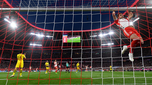 Kane se pendura no travessão após perder um gol durante Bayern x Dortmund
