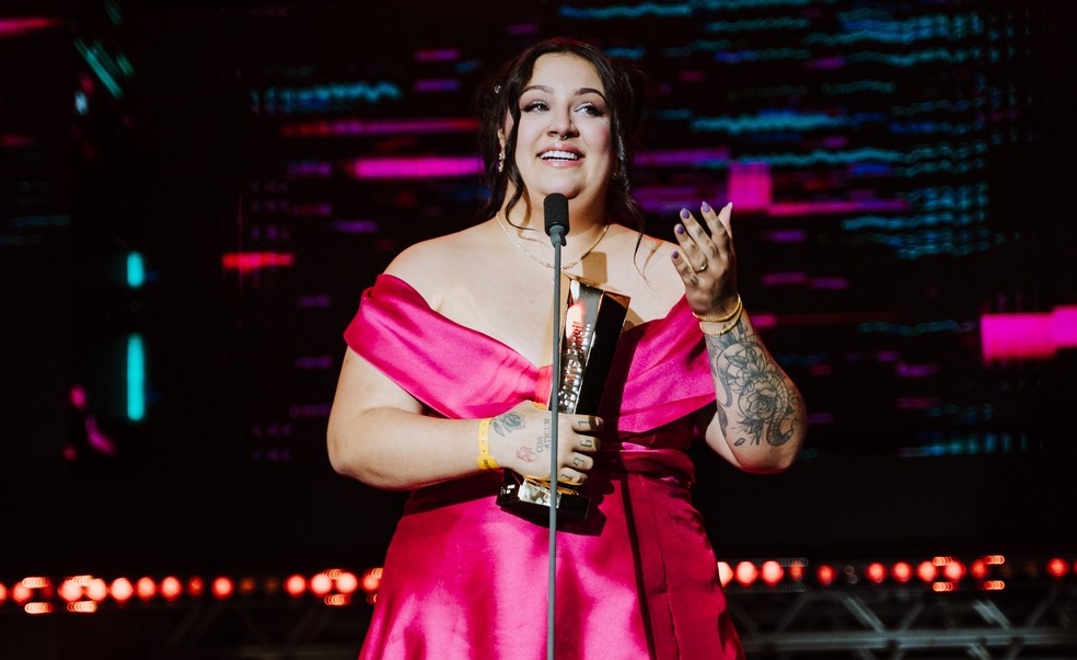 AMD22k holding the Prêmio eSports Brasil Personality of the Year trophy