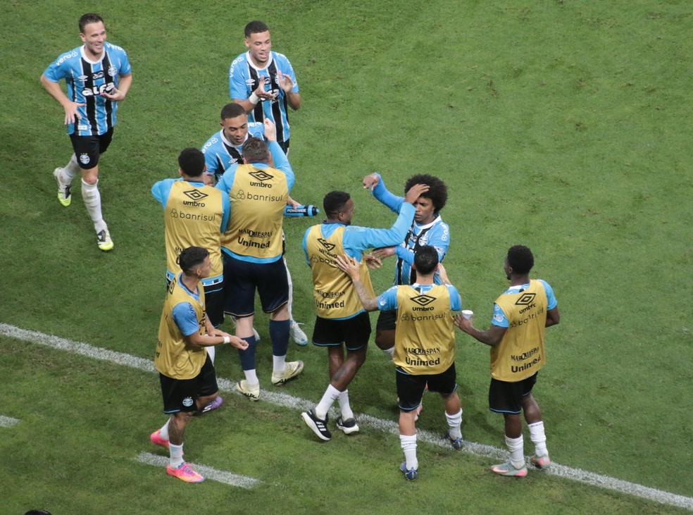 Willian foi comemorar o terceiro gol no Grêmio com Edenilson, no banco de reservas — Foto: Rafael Favero / ge.globo
