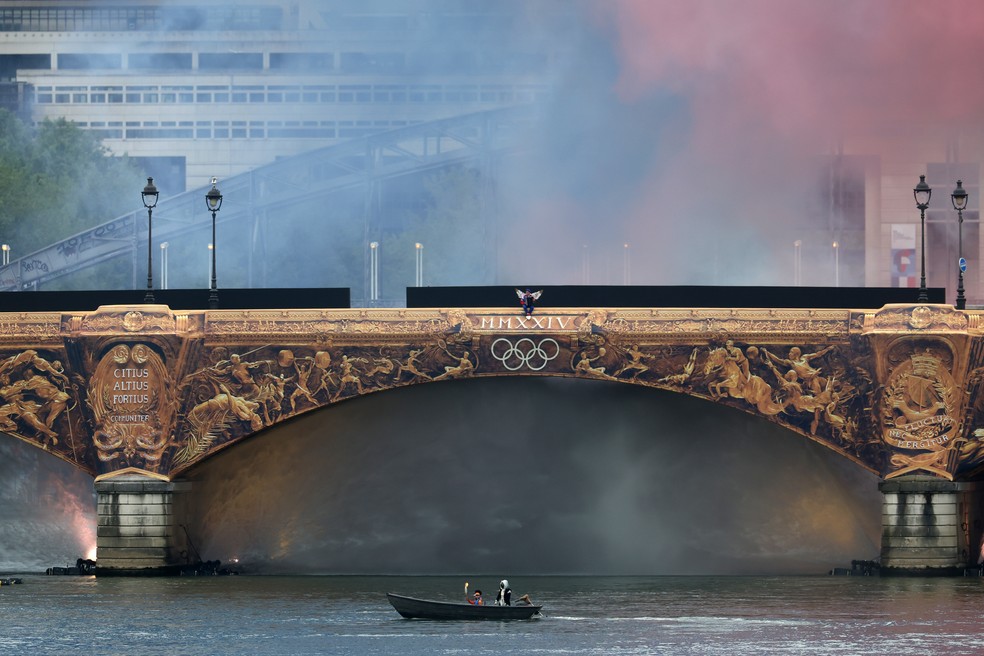 Cortina de água se forma atrás da passagem da tocha olímpica — Foto: Lars Baron/Getty Images