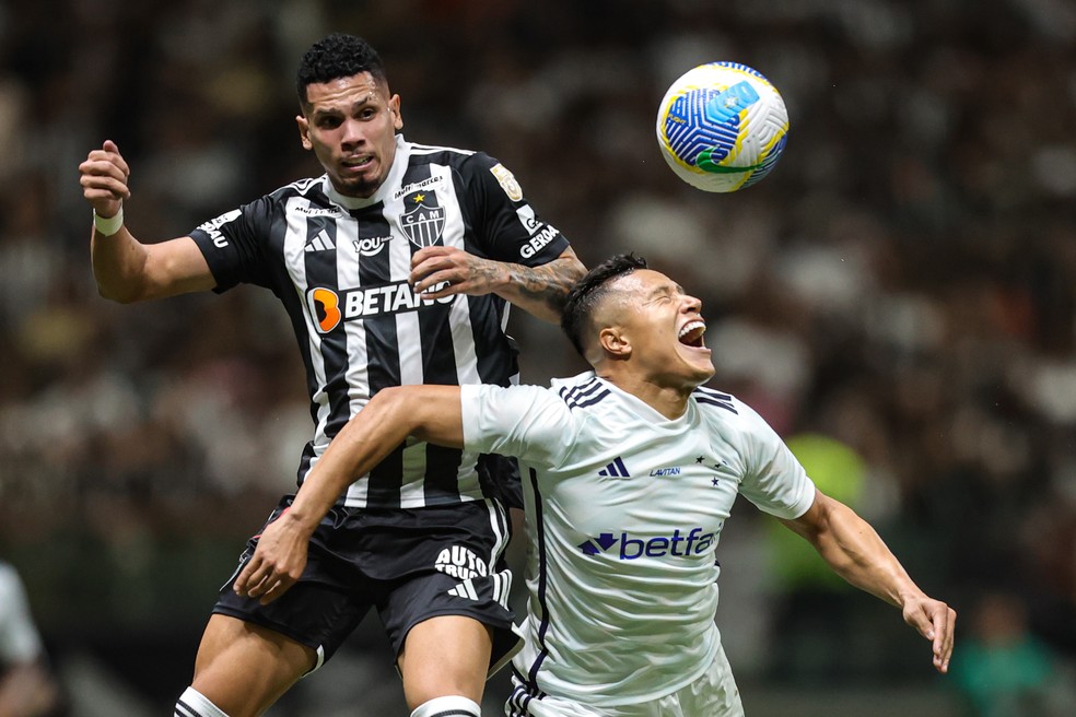 Paulinho, do Atlético-MG, em disputa de bola com Marlon, do Cruzeiro — Foto: Gilson Lobo/AGIF