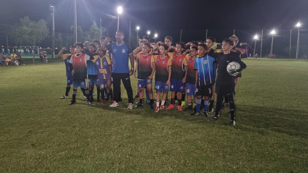 Garotos da escolinha do primeiro treinador de Tiquinho se unem para repetir comemoração do atacante — Foto: Camila Sousa/ge