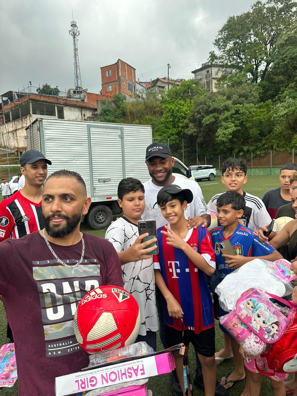 Luan posa com crianças após distribuir presentes no Morro Doce — Foto: Sarah Bueno