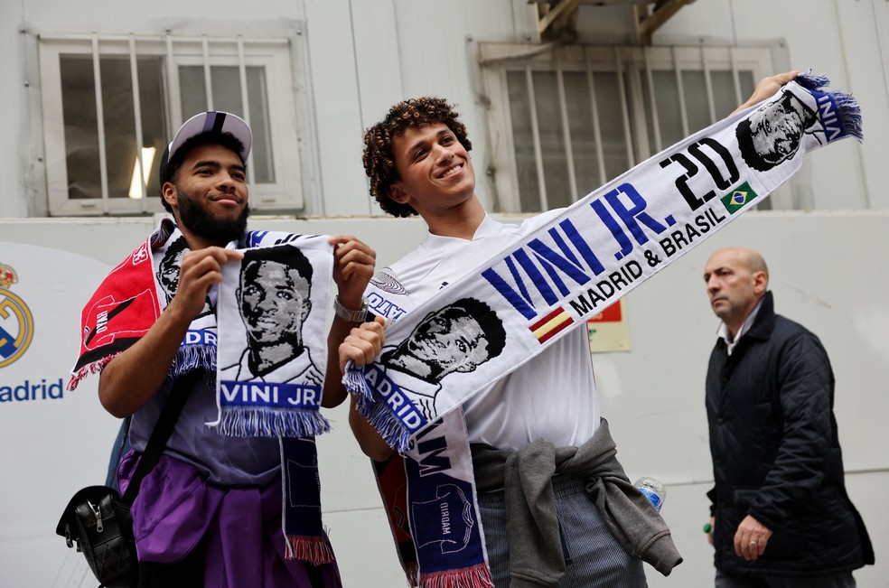 Torcedores com cachecol com o rosto de Vinicius Junior — Foto: Reuters