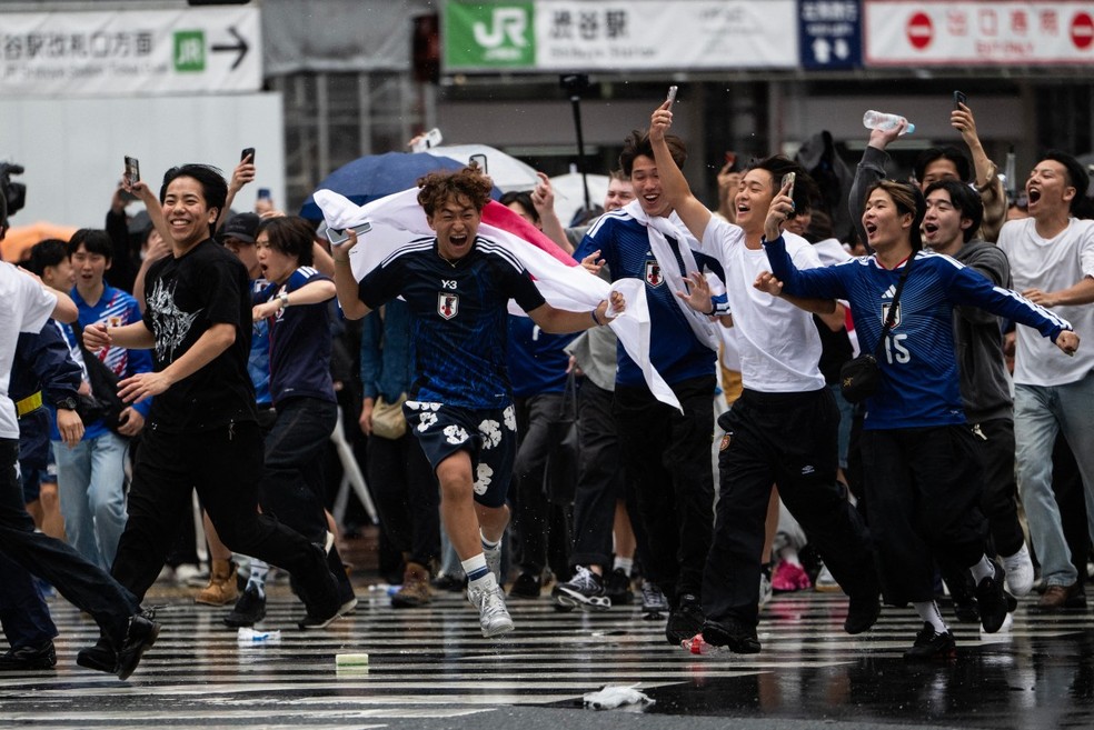 Torcedores do Japão comemoram gol sobre a Holanda — Foto: Andrew CABALLERO-REYNOLDS / AFP