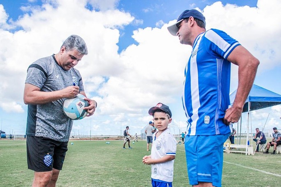 Marcelo Cabo dá autografo na bola de um torcedor azulino — Foto: Morgana Oliveira/CSA