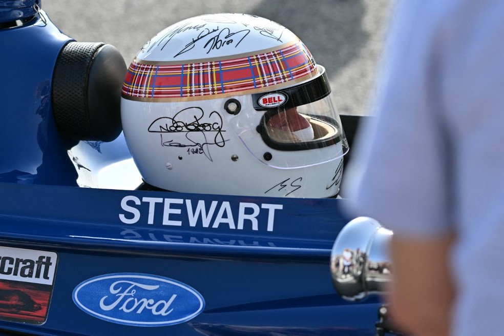 Jackie Stewart dá volta de exibição no circuito do Bahrein com capacete autografado por Michael Schumacher — Foto: Andrej Isakovic/AFP