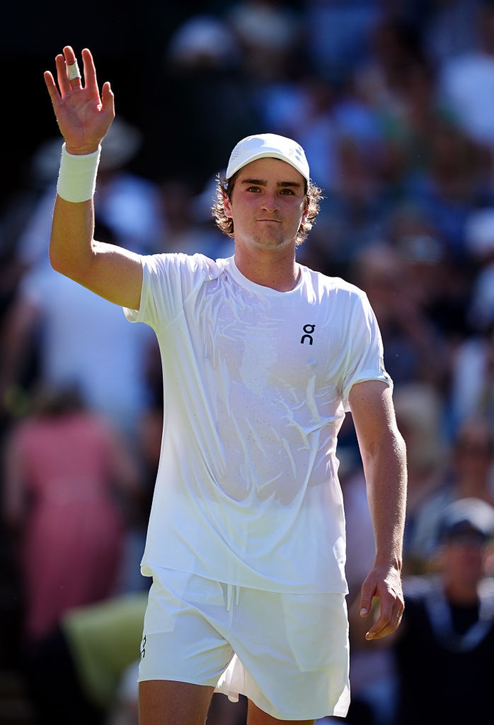 João Fonseca em ação durante partida de Wimbledon, jovem tenista brasileiro faz história ao avançar, demonstrando espírito esportivo após incidente com torcedora.