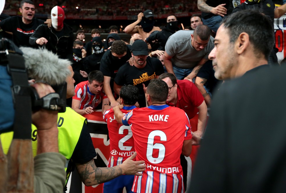 Koke e Giménez conversam com "ultras" do Atlético de Madrid, com alguns membros mascarados: clube proíbe prática em seus jogos após confusão em clássico com Real Madrid — Foto: Florencia Tan Jun/Getty Images)