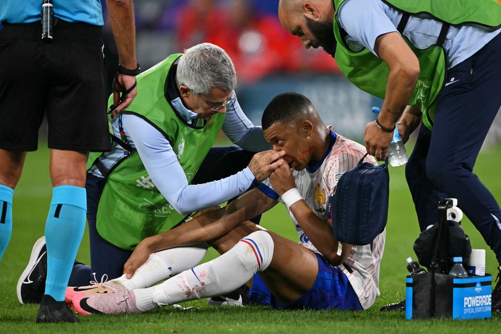 Mbappé recebe atendimento após o choque no nariz em Áustria x França — Foto: Ozan Kose/AFP