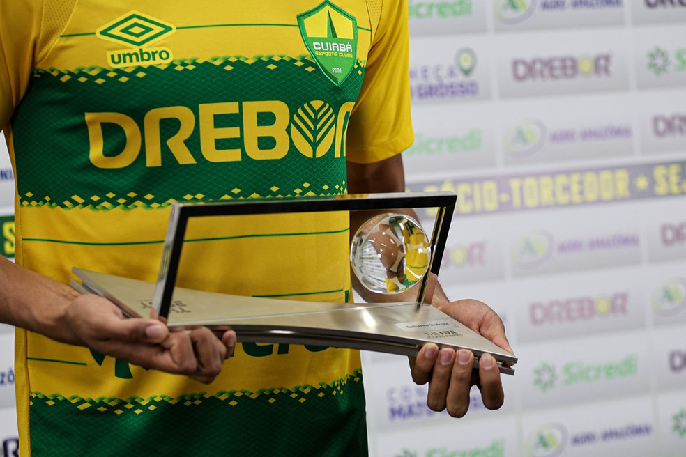 Guilherme Madruga com o troféu do Prêmio Puskás na apresentação no Cuiabá — Foto: AssCom Dourado