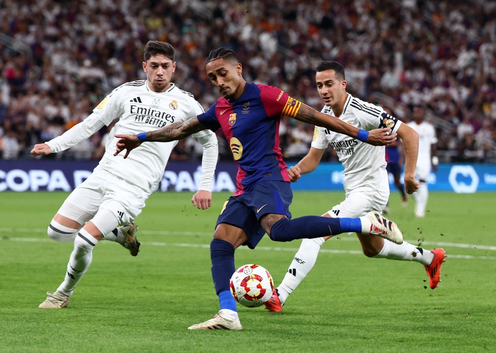 Raphinha perseguido por Valverde e Lucas Vázquez na final da Supercopa da Espanha, entre Real Madrid e Barcelona — Foto: REUTERS/Pedro Nunes