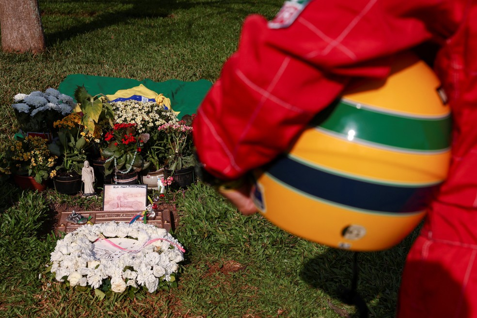 Fã de Senna presta homenagem em frente ao túmulo do tricampeão mundial de F1 — Foto: Reuters