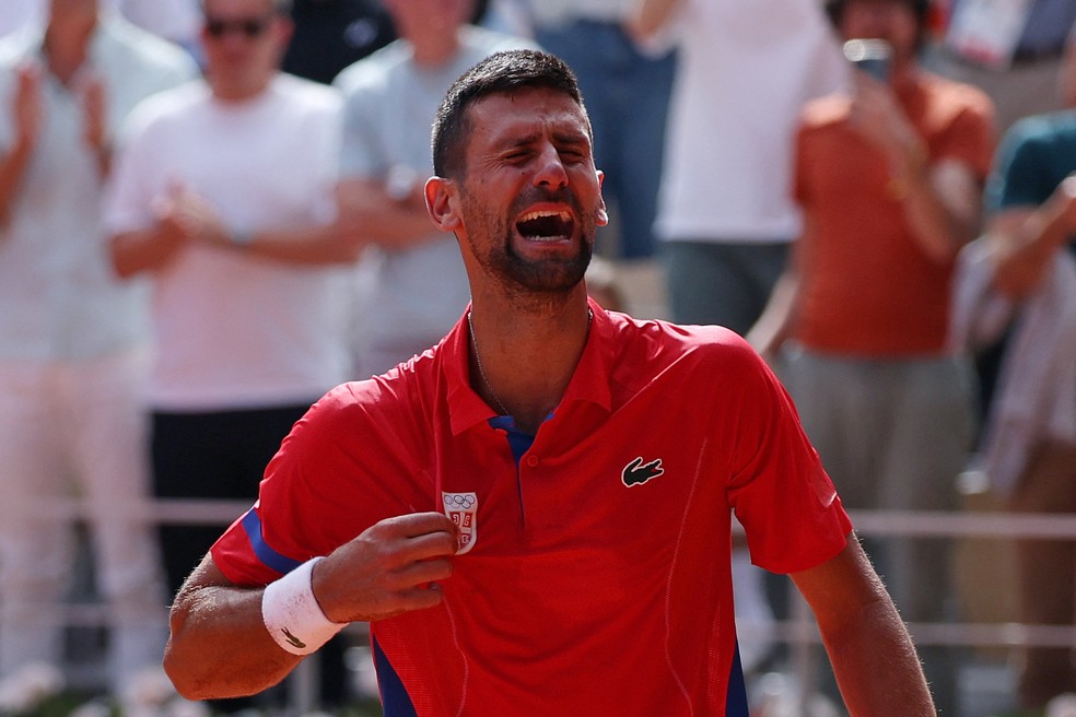 Novak Djokovic comemora ouro no tênis após vitória sobre Carlos Alcaraz na final nas Olimpíadas de Paris 2024 — Foto: REUTERS/Claudia Greco