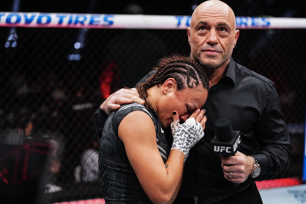 Michelle Waterson-Gomez chora no ombro de Joe Rogan ao se aposentar no UFC 303 — Foto: Jeff Bottari/Zuffa LLC via Getty Images