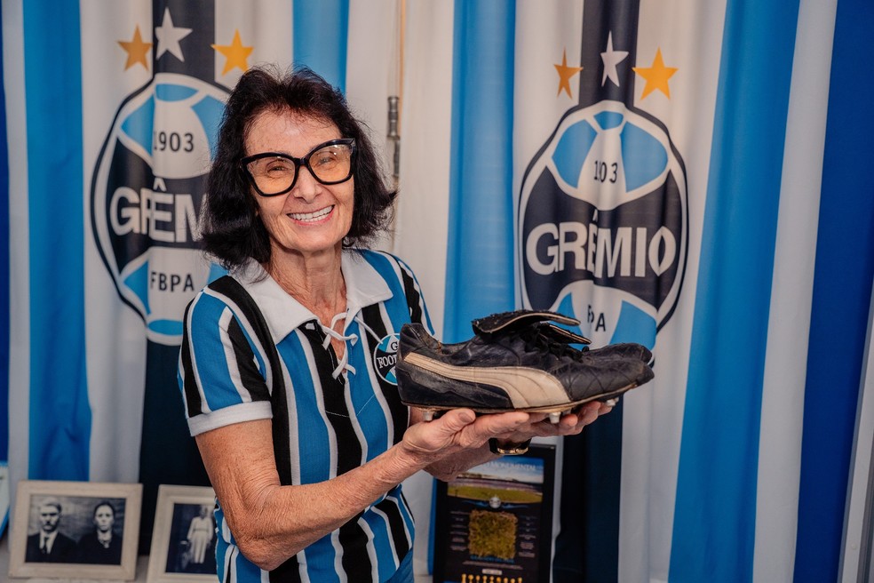 Mercedes Cerutti com um par de chuteiras que ganhou do volante China, campeão do mundo pelo Grêmio em 1983