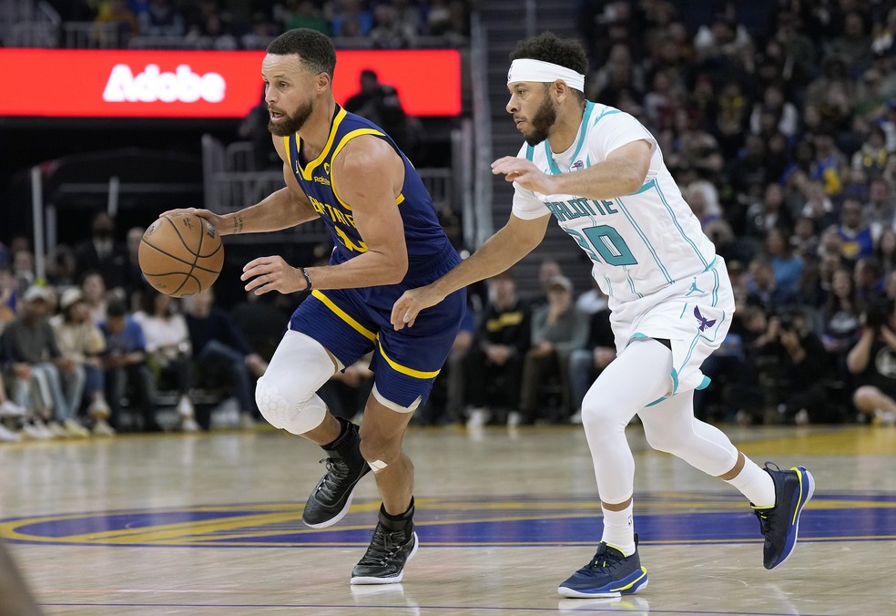 Stephen Curry avança em direção à cesta driblando seu irmão, Seth Curry — Foto: Getty Images