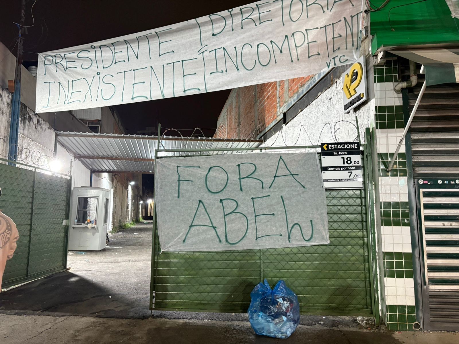 Torcedores do Palmeiras protestam com faixas após derrota em tom profissional.