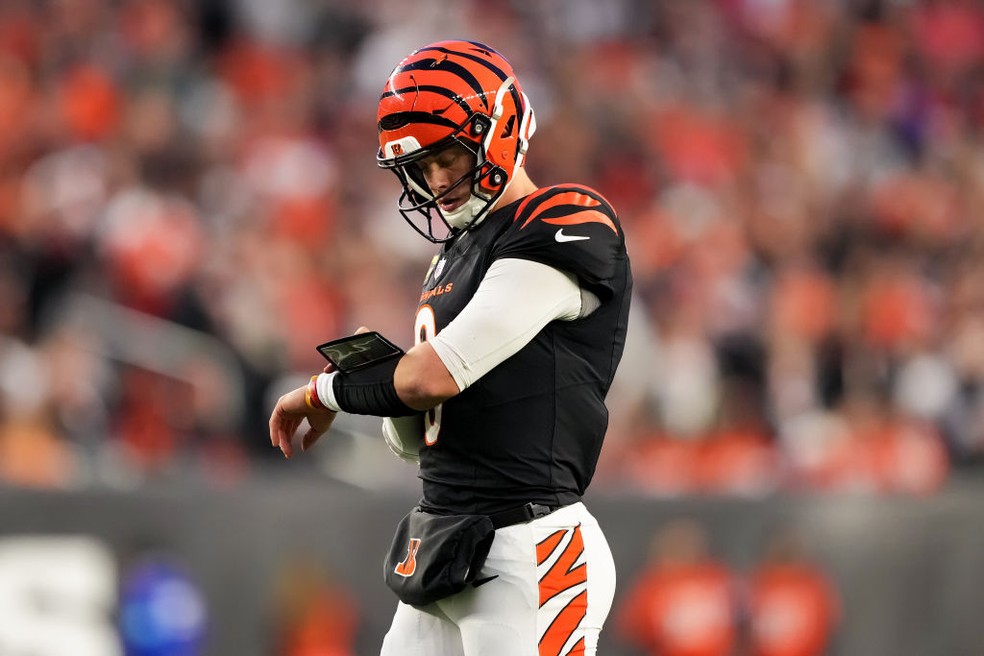 Joe Burrow olha munhequeira tática durante partida da NFL