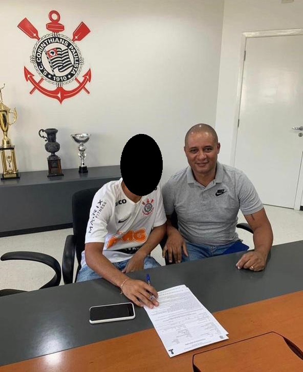 José Ricardo com outro jogador assinando contrato na base do Corinthians — Foto: ge