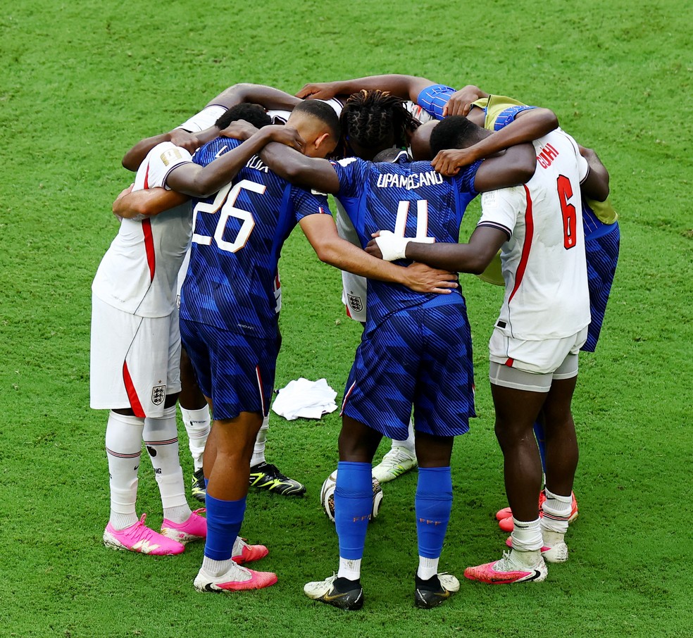Jogadores de França e Inglaterra rezam juntos no gramado — Foto: REUTERS/Marco Bello