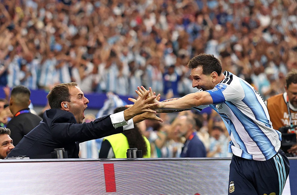 Lionel Messi comemora segunda gol da Argentina com jornalista Joaquín Bruno — Foto: Maja Hitij - FIFA/FIFA via Getty Images