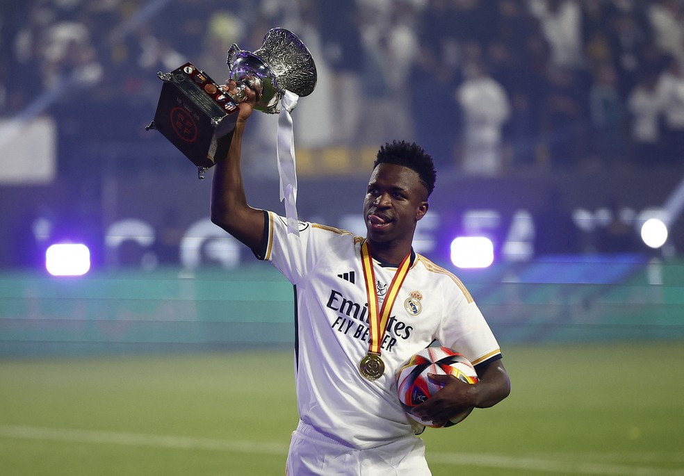 Vinicius Junior, do Real Madrid, com a taça da Supercopa e a bola do jogo após hat-trick em cima do Barcelona — Foto: Juan Medina/Reuters