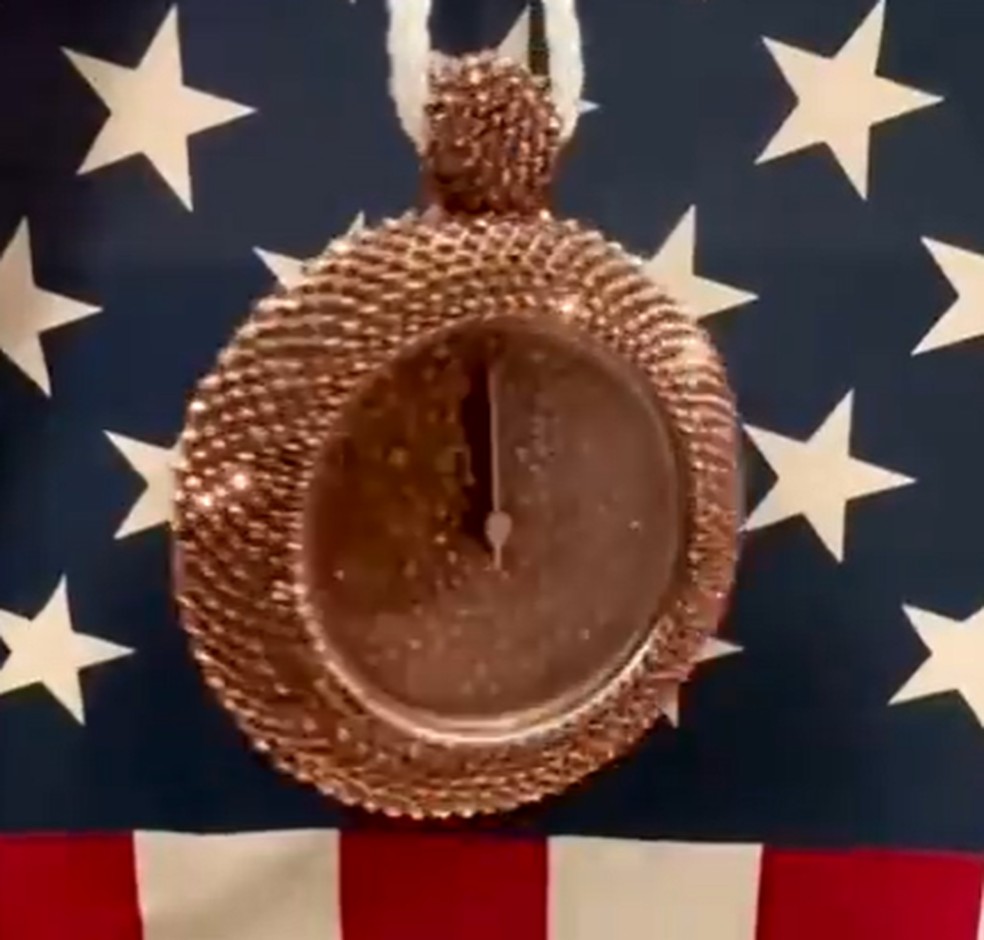 Relógio de bronze que Flavor Flav deu de presente para Jordan Chiles — Foto: Reprodução