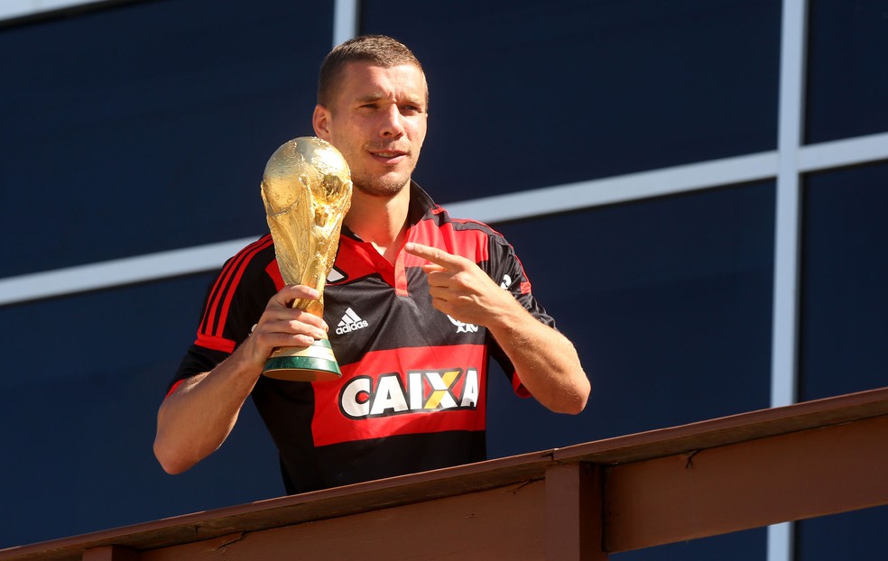 Vestido com a camisa do Flamengo, Podolski ergue a taça da Copa do Mundo de 2014 — Foto: André Durão
