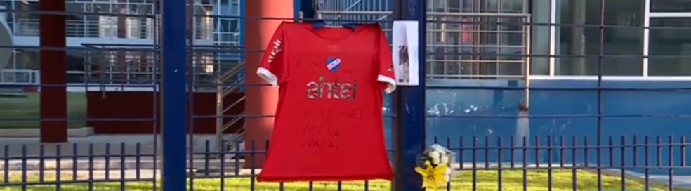 Camisa de Izquierdo pendurada na fachada da sede do Nacional-URU, com flores e homenagens após morte do jogador — Foto: Reprodução / Subrayado