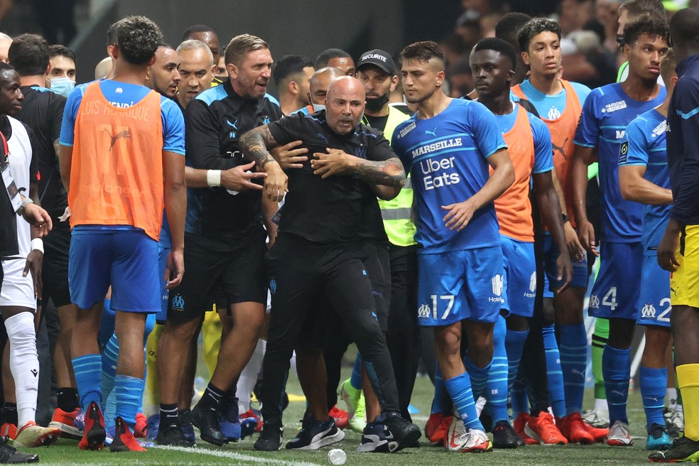Jorge Sampaoli é contido por seguranças, companheiro de comissão técnica e jogadores do Olympique de Marselha na confusão com torcedores do Nice  — Foto: Valery HACHE / AFP