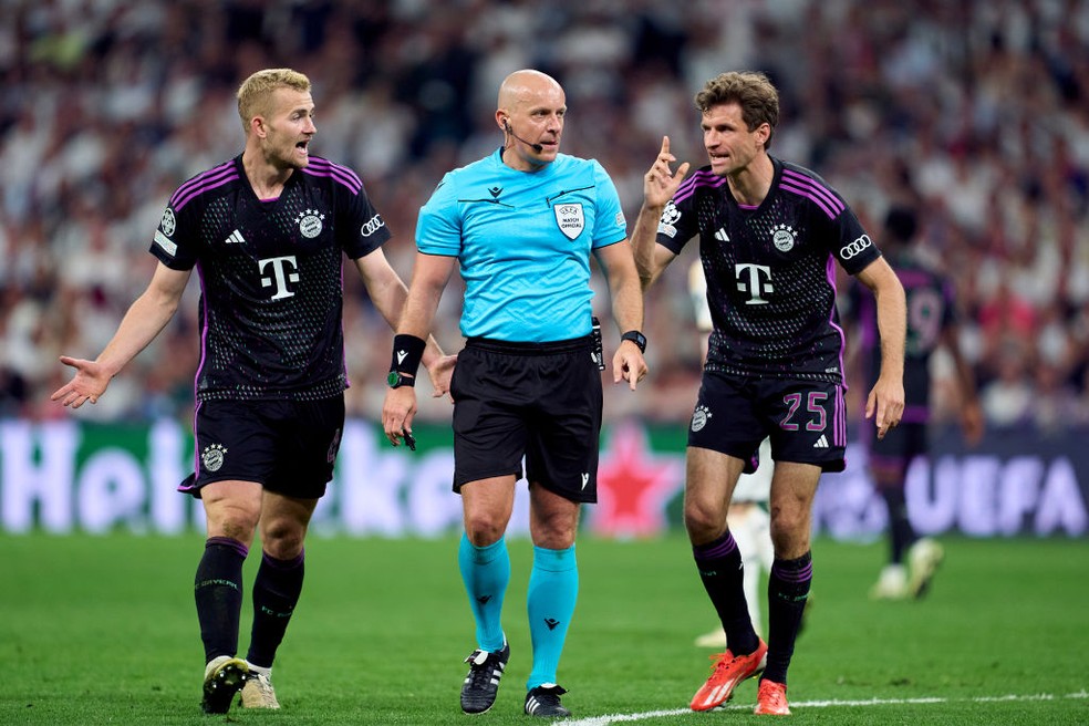 De Ligt (esq.) e Thomas Muller (dir.) reclamam com Szymon Marciniak em Real Madrid x Bayern de Munique — Foto: Mateo Villalba / Getty Images
