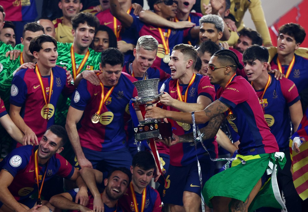 Raphinha segura a taça da Supercopa da Espanha, vencida pelo Barcelona contra o Real — Foto: REUTERS/Pedro Nunes