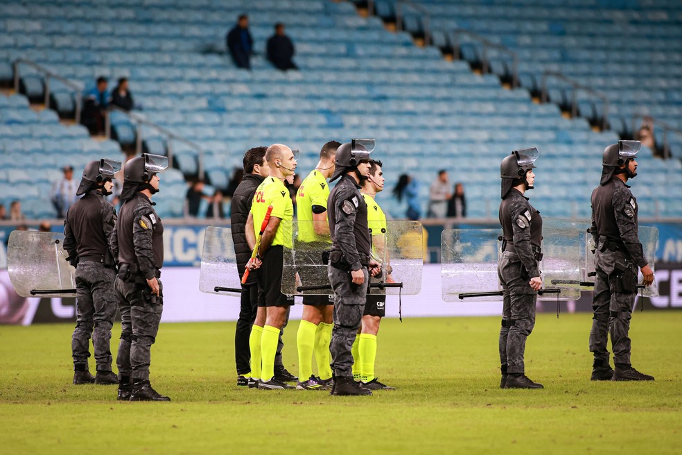 O árbitro Matheus Candançan escoltado pela polícia após a partida entre Grêmio e CSA na Arena