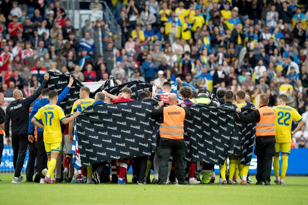 Dinamarca x Ucrânia jogadores se reúnem em volta de Eriksen — Foto: BO AMSTRUP / RITZAU SCANPIX / AFP