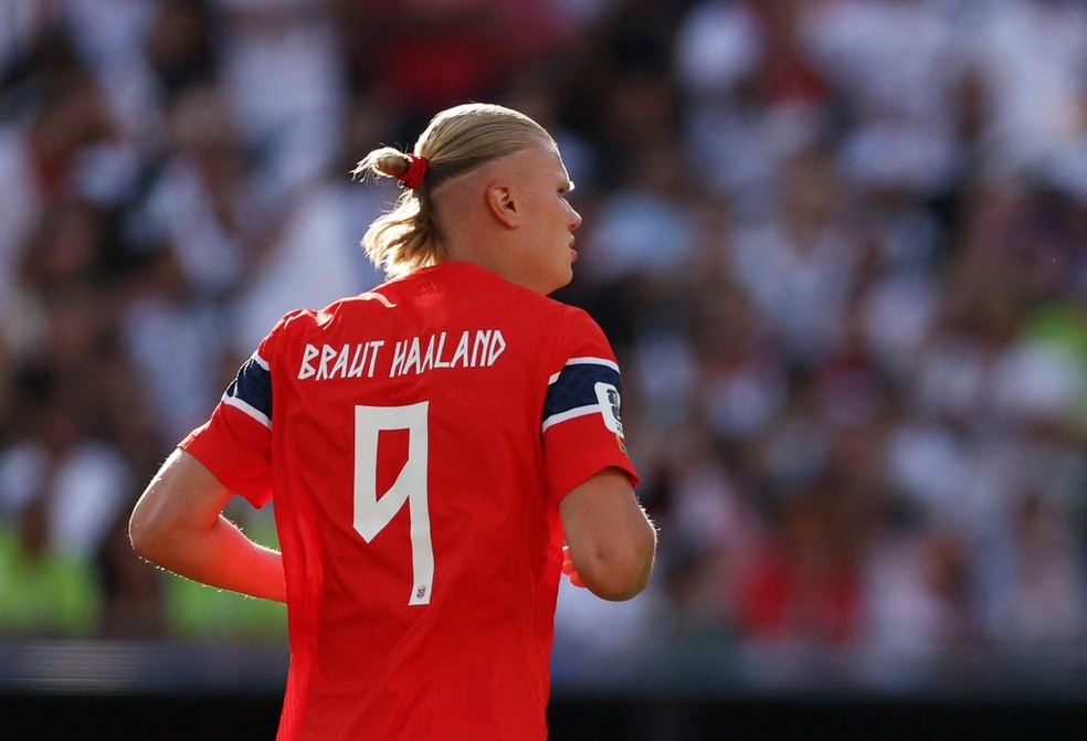 Haaland com a xuxinha vermelha combinando com o uniforme titular da Noruega