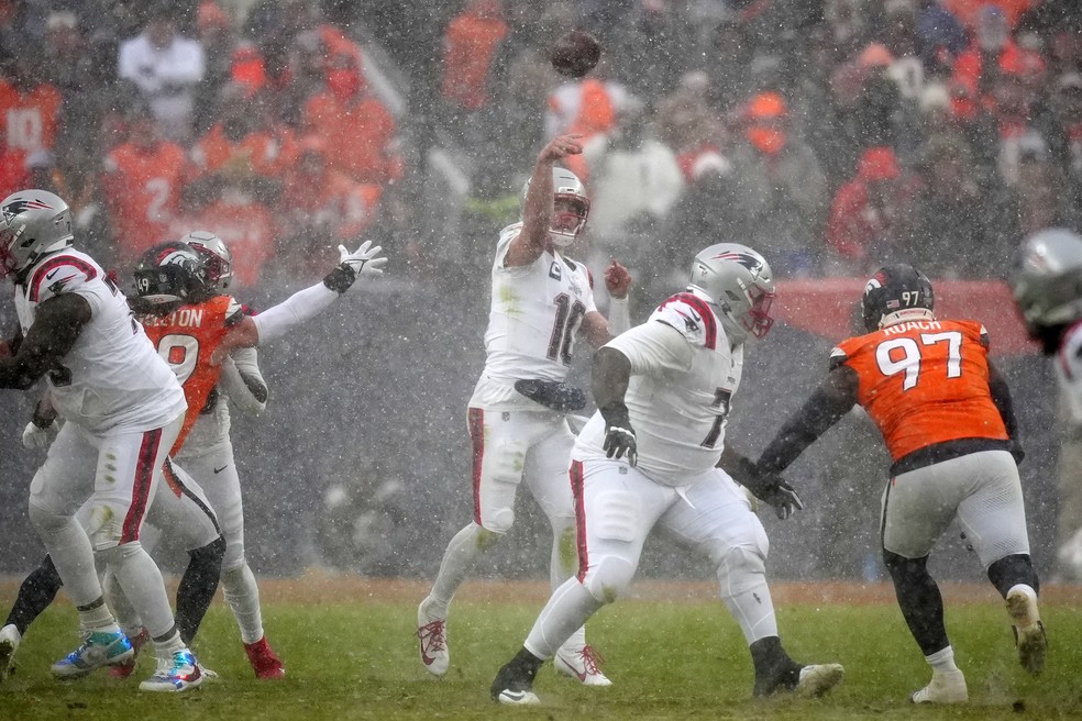 Drake Maye (10), do New England Patriots, dá um passe debaixo de neve contra o Denver Broncos, na final da Conferência Americana  — Foto: Ron Chenoy/IMAGN IMAGES via Reuters Connect