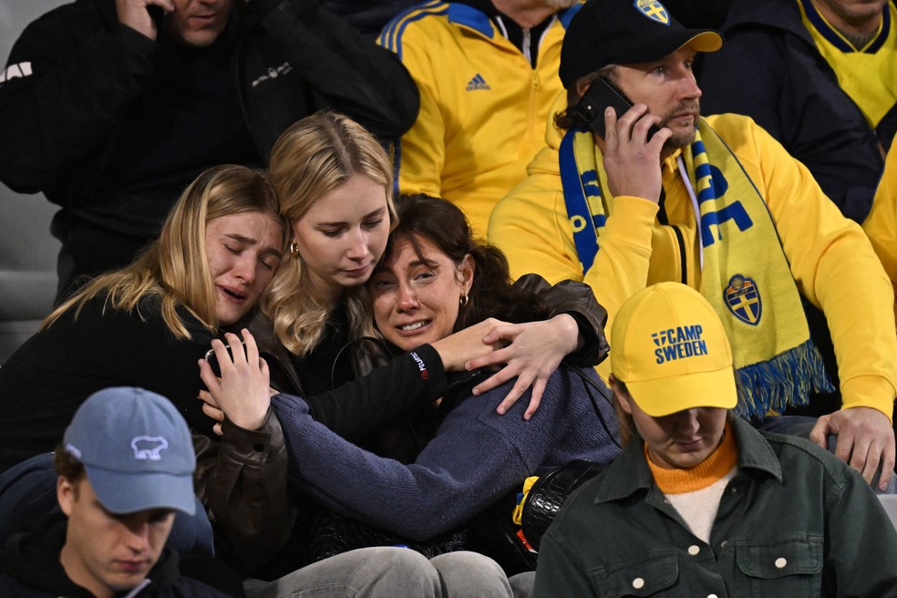 Torcedoras da Suécia choram após morte de suecos antes de jogo com a Bélgica, nas eliminatórias da Eurocopa — Foto: John Thys/AFP