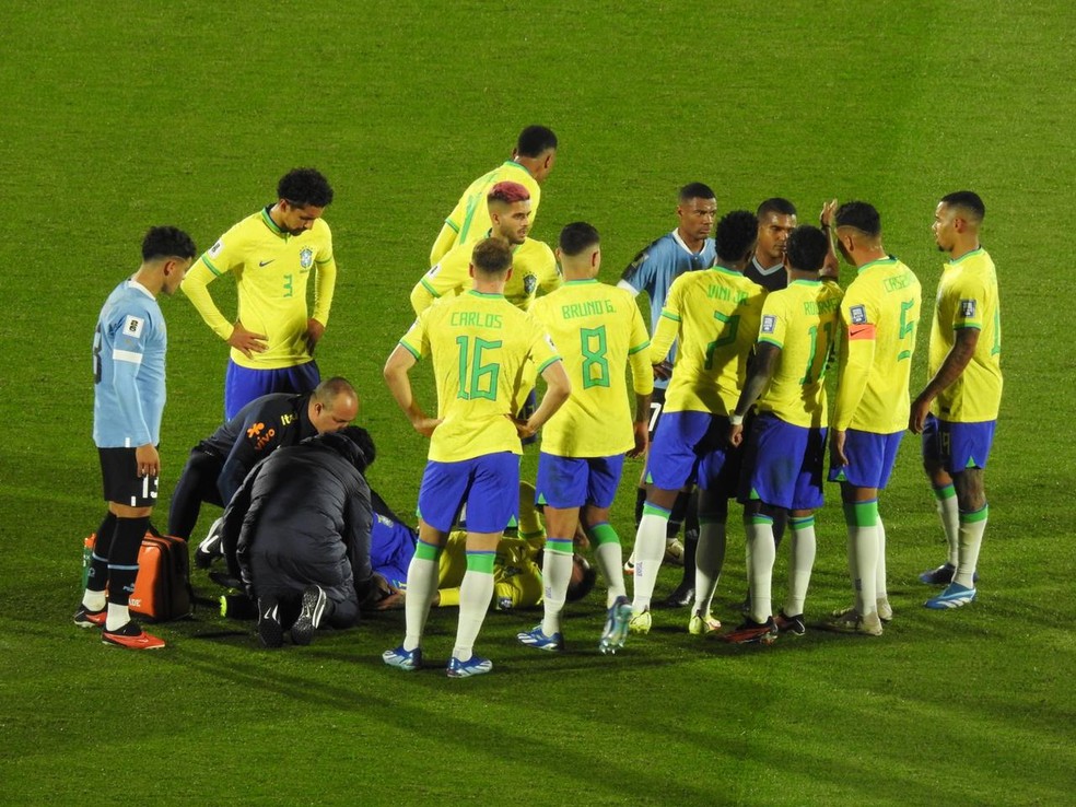 Các cầu thủ đội tuyển quốc gia vây quanh Neymar, bị chấn thương, trên sân - Ảnh: Bruno Cassucci/ge