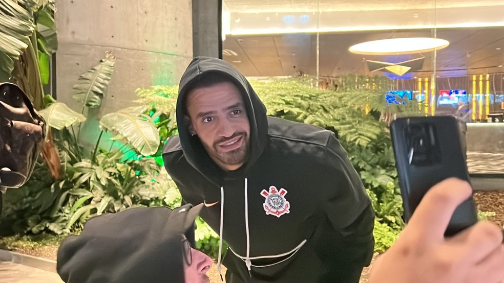Renato Augusto tira foto com torcedor na chegada do Corinthians à Argentina — Foto: Marcelo Braga