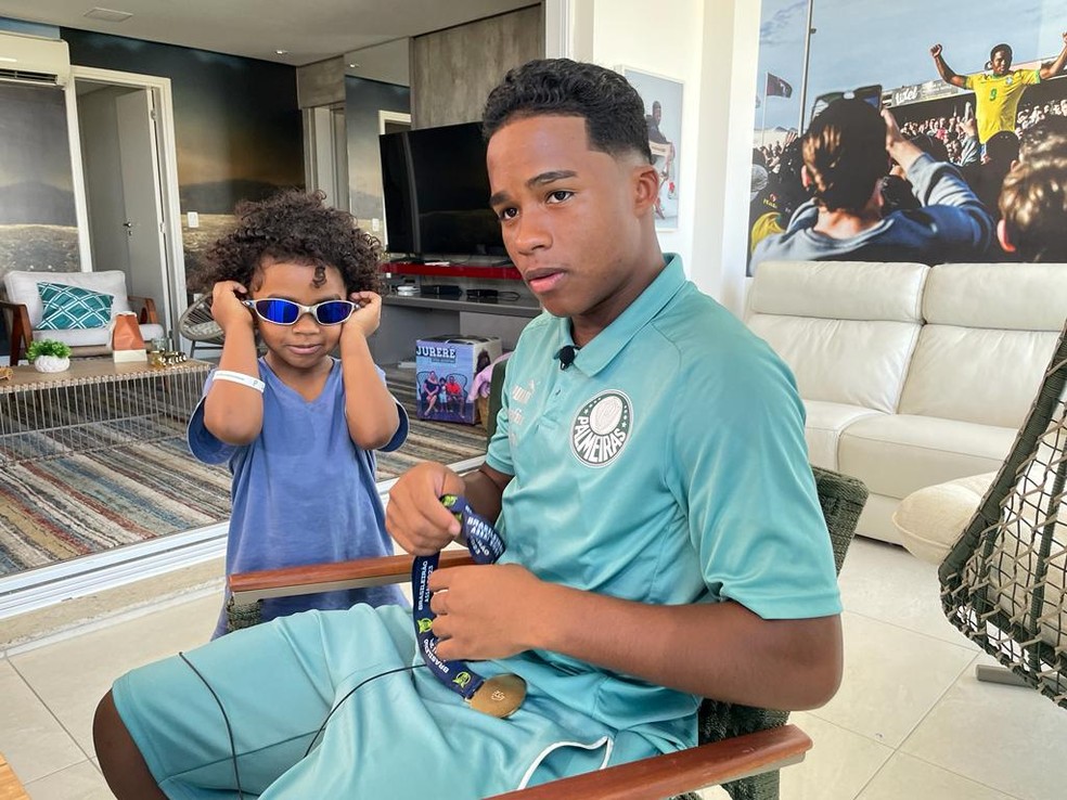 Na varanda de casa, Endrick segurando a medalha de campeão brasileiro e ao lado do irmão, Noah — Foto: Camila Alves