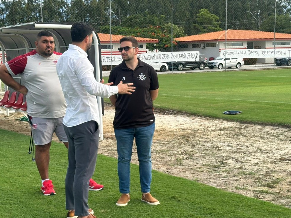 Ari Barros no CT do CRB com as faixas da torcida ao fundo — Foto: Rodrigo Cedro/TV Asa Branca