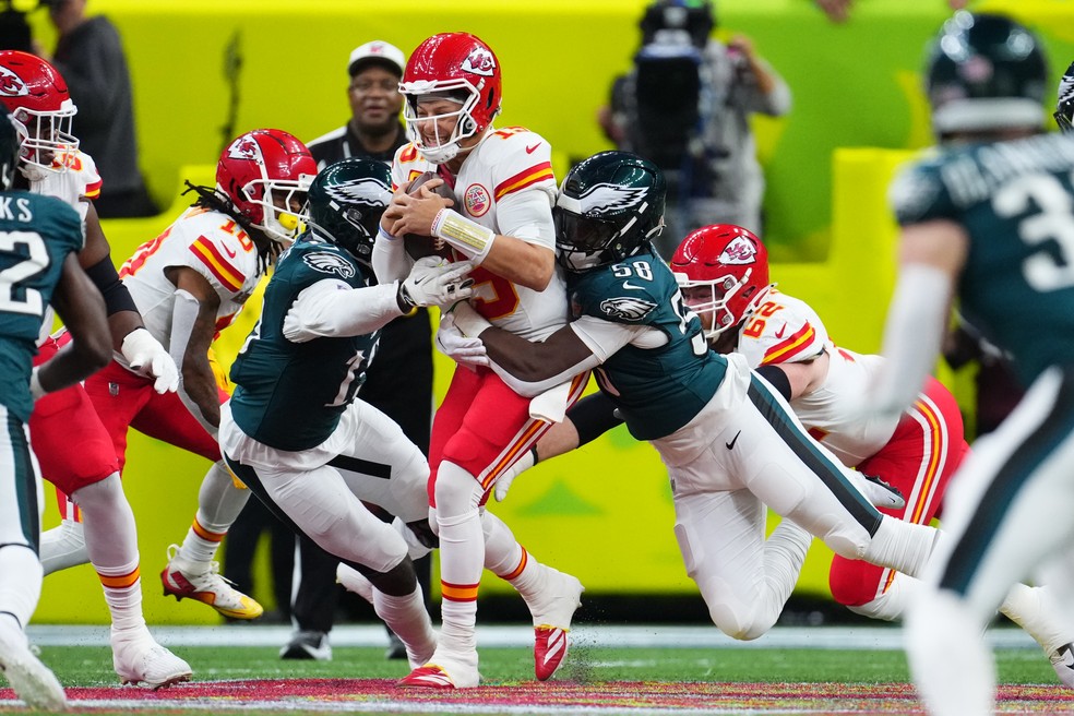 Patrick Mahomes (centro), do Kansas City Chiefs, é derrubado por dois jogadores do Philadelphia Eagles no Super Bowl LIX — Foto: Cooper Neill/Getty Images
